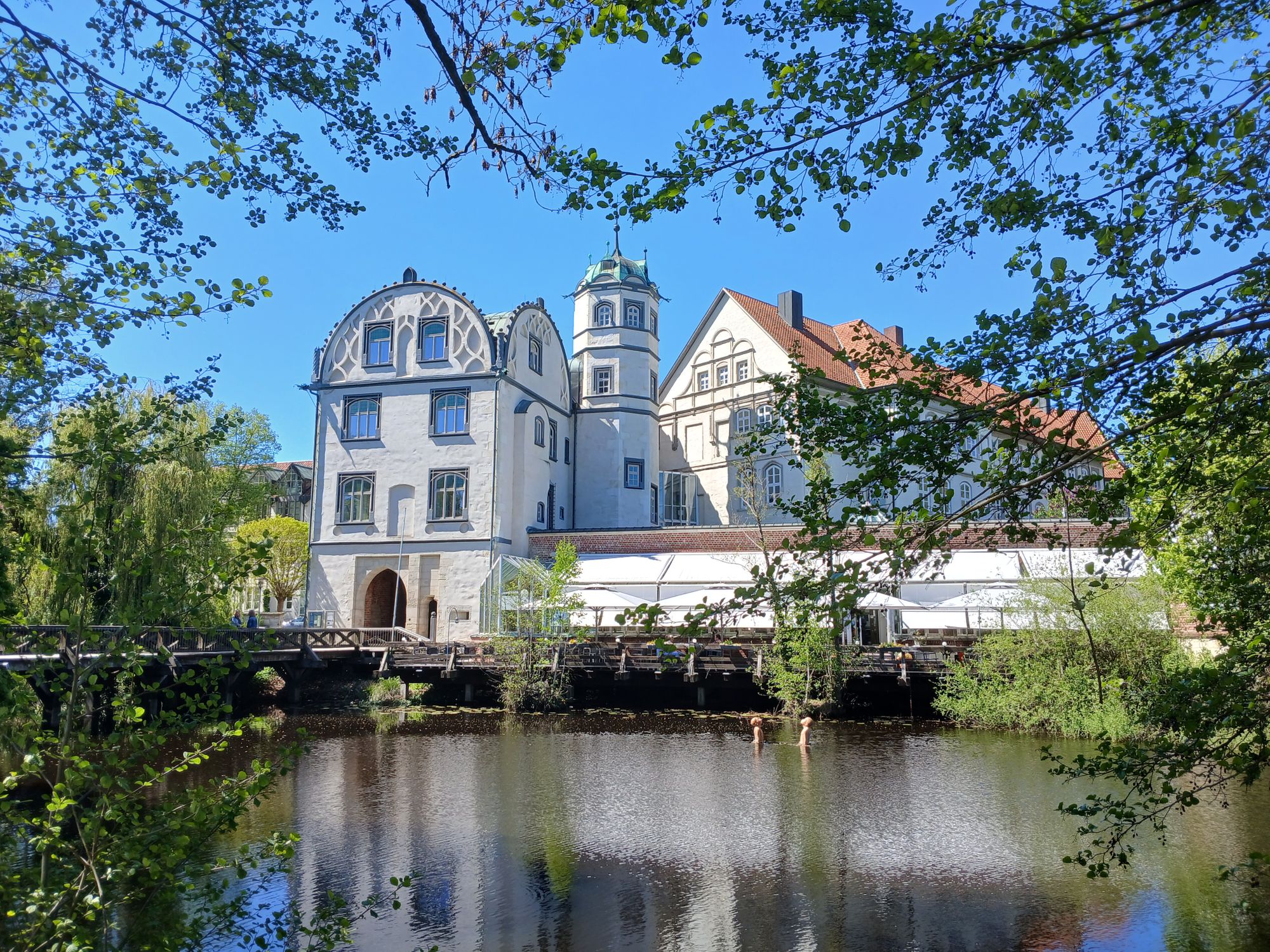 AI generated caption: Historic white building reflected in calm river. AI generated caption: Historic white building reflected in calm river.