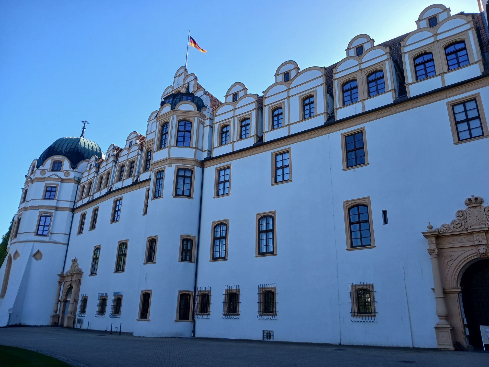 AI generated caption: Historic white castle with flag flying on tower. AI generated caption: Historic white castle with flag flying on tower.