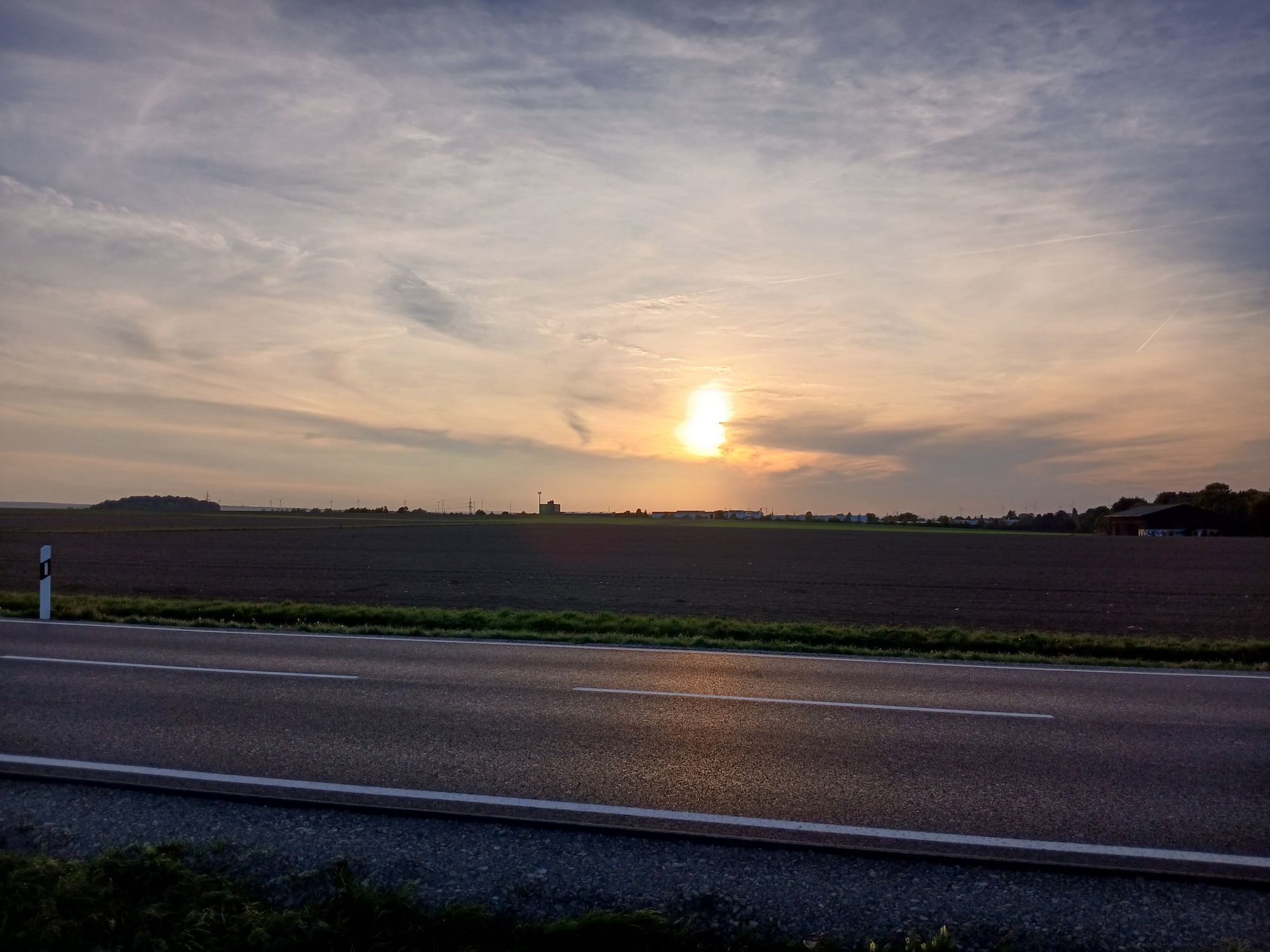 AI generated caption: Sun setting over empty highway and fields. AI generated caption: Sun setting over empty highway and fields.