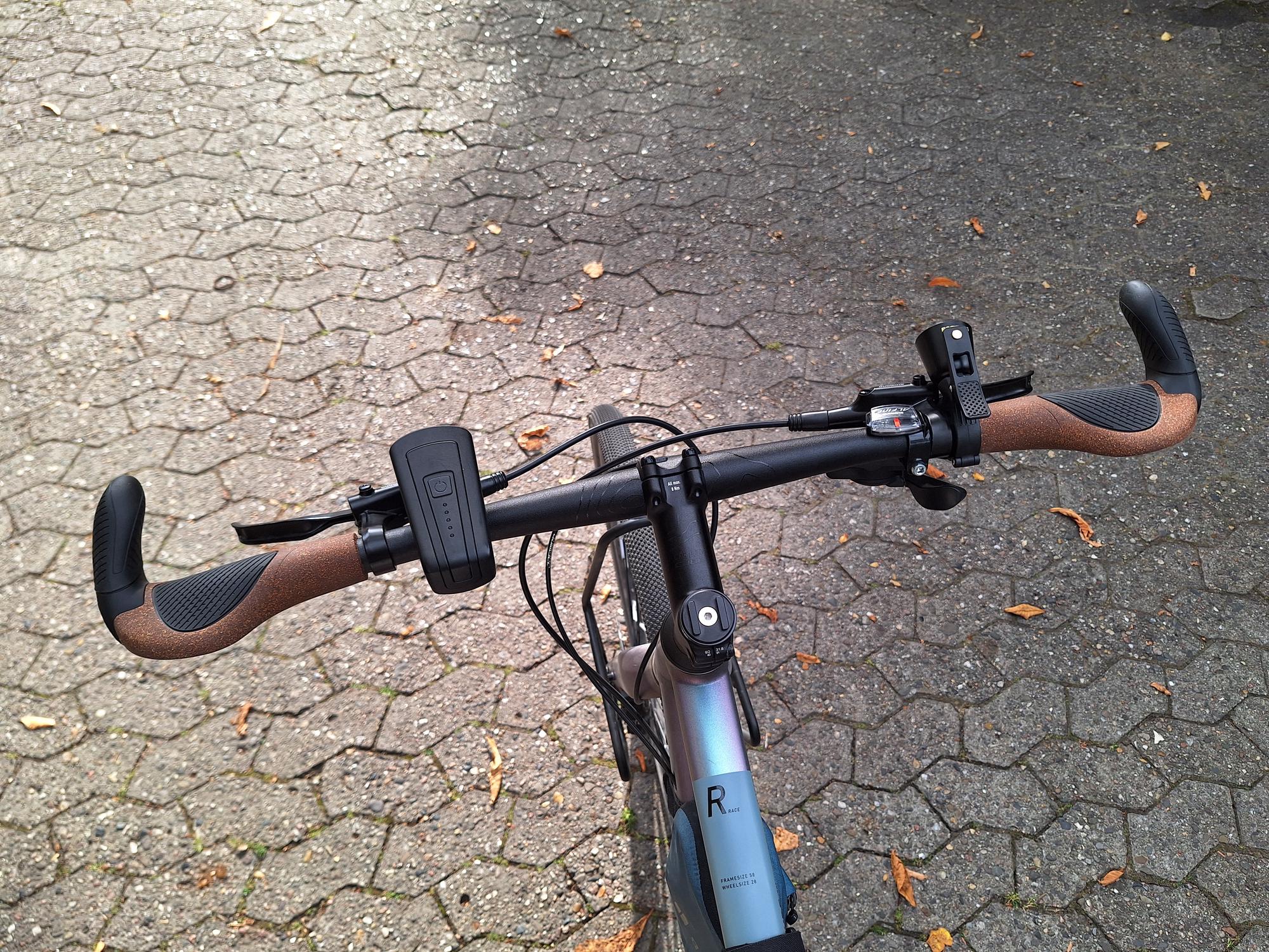 My bike handlebars with new grips and a new bell

AI generated caption: Bicycle handlebars with grips and mounted devices.